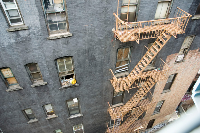 Seen from above, a fire escape runs down the side of a building.