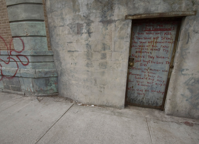 The Ten Commandments have been clumsily hand painted on a door.