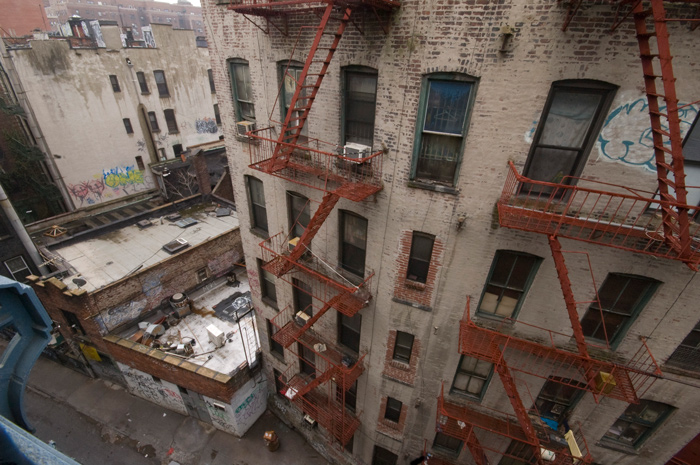 Fire escapes snake down the side of a tenement in Chinatown.