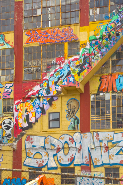 Half of the external staircase has fallen off a graffiti-covered building.