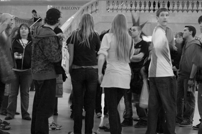 Amid a crowd of newly arrived teenagers, one teen sports a wild haircut.