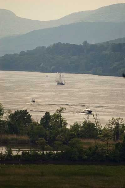A sailboat on the Hudson River, with hills in the distance.