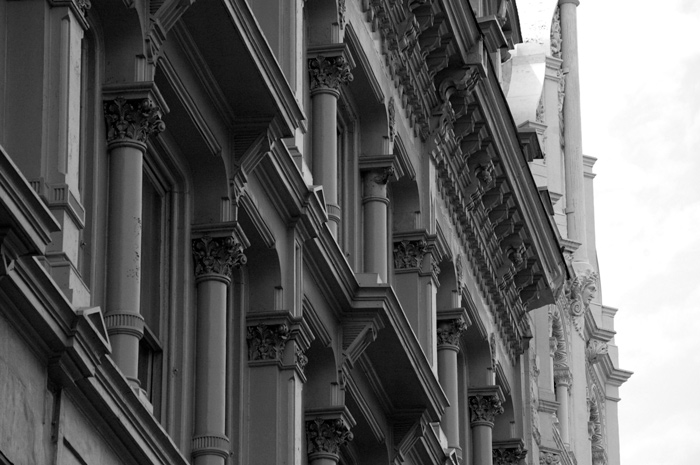 The upper floors of a building are decorated with columns.