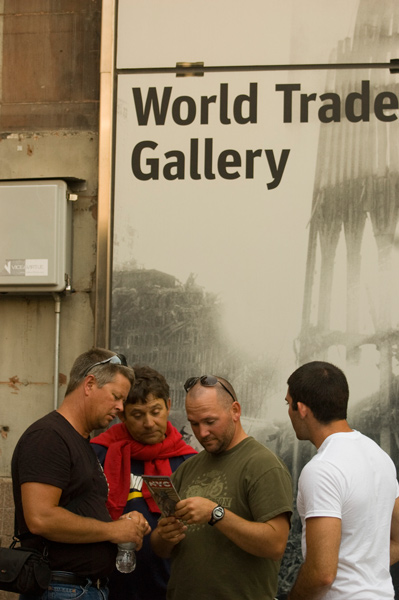 Four tourists consult a visitors brochure while standing outside a gallery memorializing September 11 and the World Trade Center attacks.