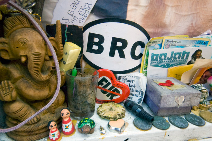 A collection of odd memorabilia, including foreign coins, postcards, a carved Ganesha, and such.