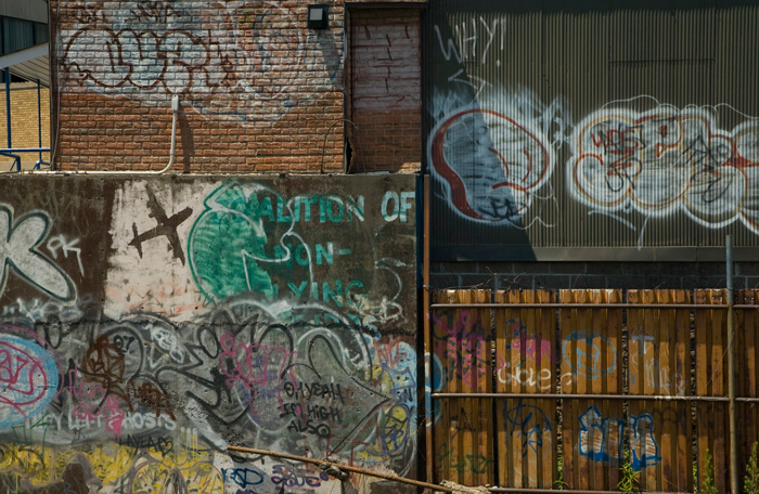 A variety of brick and metal surfaces have been covered in graffiti, street art, and political slogans.