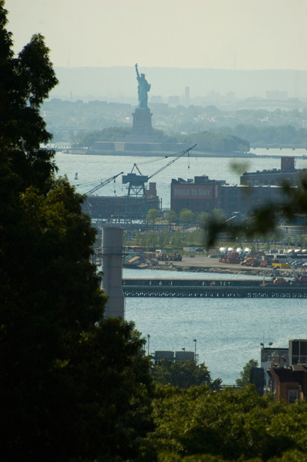 The Statue of Liberty, seen in the distance, sandwiched between Brooklyn and New Jersey.