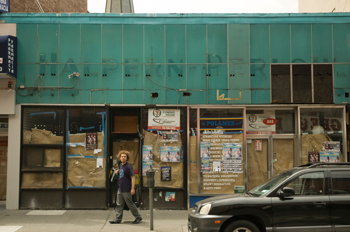 Above a store in transition, the remnants of an old neon sign for a former tenant, Halpern-Perlow, are visible.