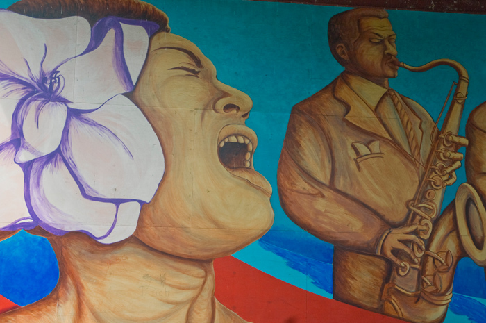 A mural shows Billie Holida singing, with a flower in her hair; the saxophonist Illinois Jacquet is shown next to her.