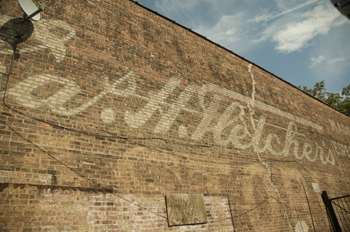 A faded wall sign advertises Fletcher's Castoria, with the Fletcher name in script.