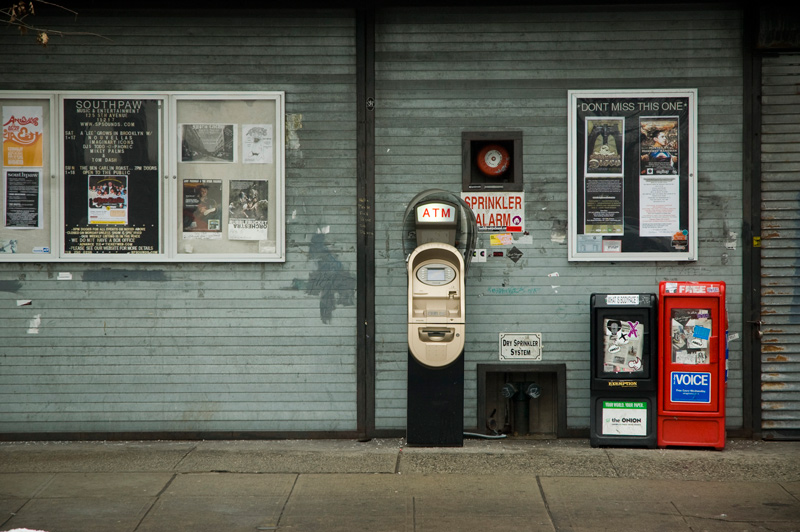 A nightclub's front gates are rolled down, with only its sign for future shows indicating its business.