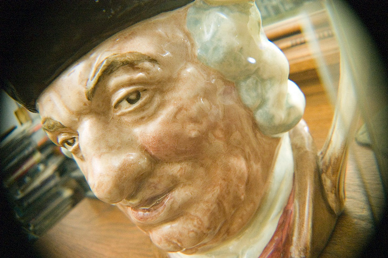 A Toby Mug of Samuel Johnson sits on top of a mantel.