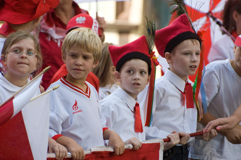 A row of children dressed in red and white wait to march in a Polish heritage parade.