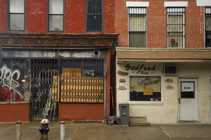 A street level apartment decorated with restaurant signage.