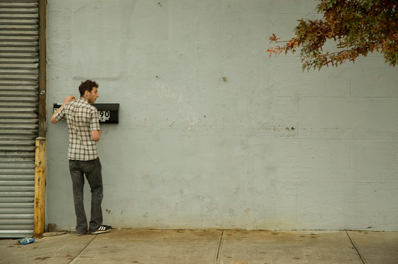 A man reaching into his mailbox.