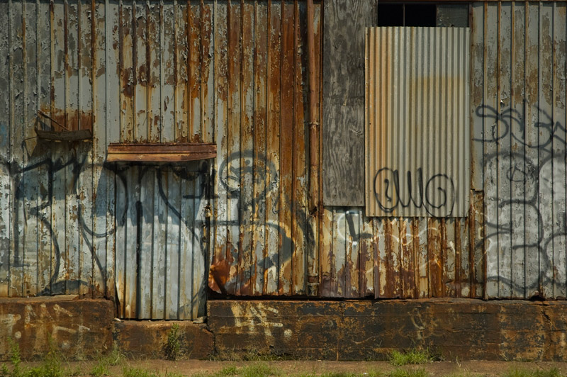 A wall of corrugated metal is rusted