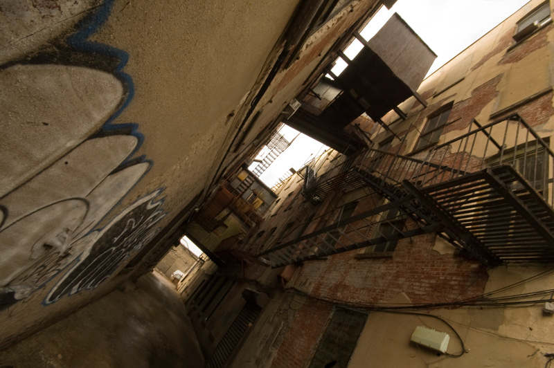 Fire escapes through and around a tight, old alley.