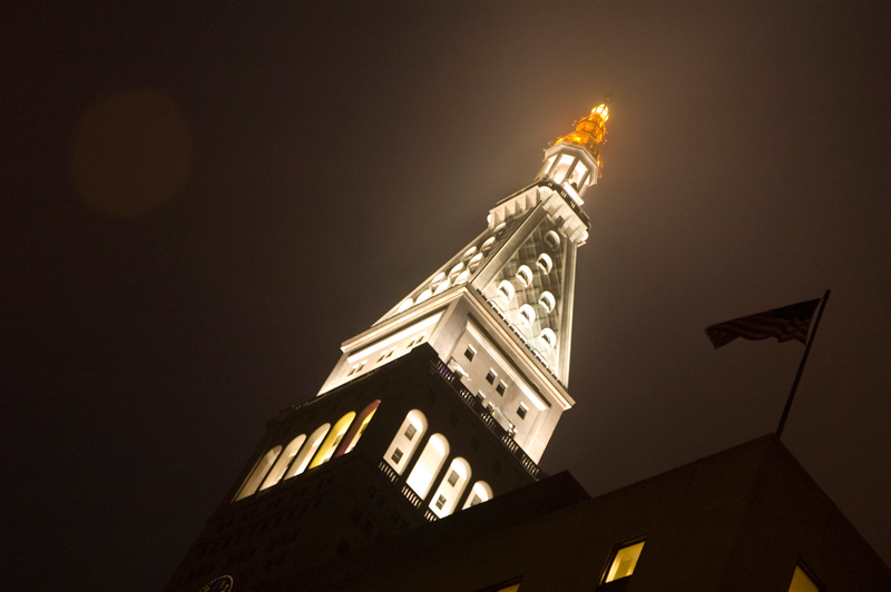 A pyramid-topped building is lit in the night.