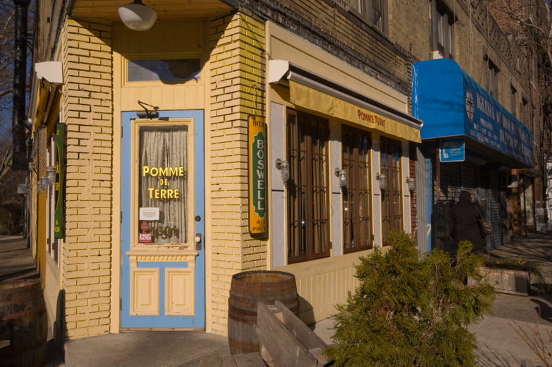 Sun shines on the gold leaf lettering on a restauarant's front door.