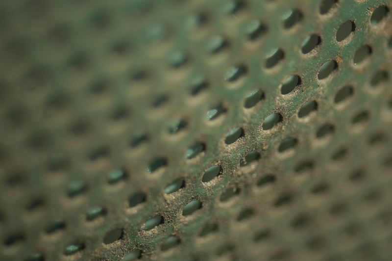Detailed look at the metal cross-hatch structure of a litter basket.