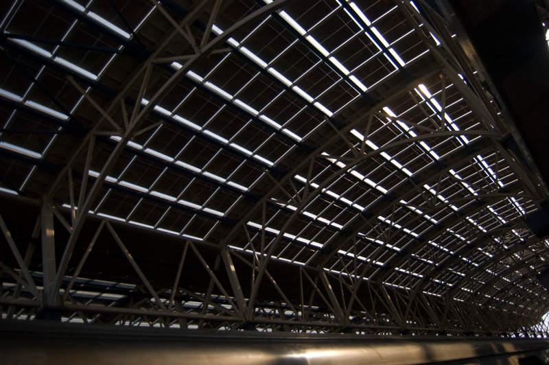 A long ceiling, dominated by metal arches and cross supports.