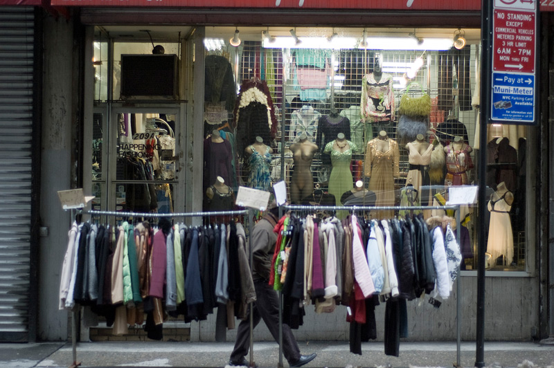 A man walks by racks of coats in the garment district.