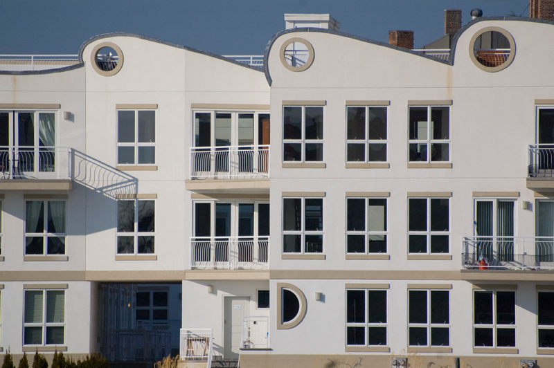 A modern white building with many windows and balconies.