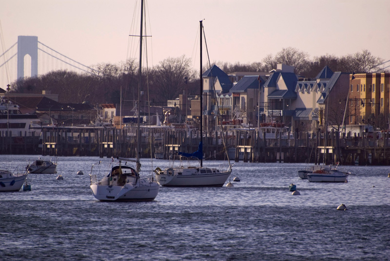 Sailboats sit anchored in a bay.