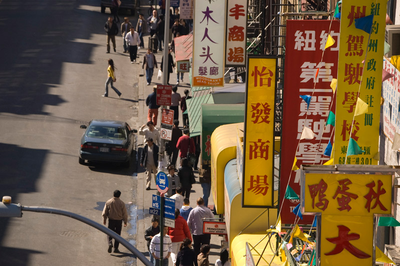 Colorful signs on a street with pedestrians.