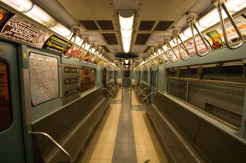 The interior of a subway car, from one end to the other.