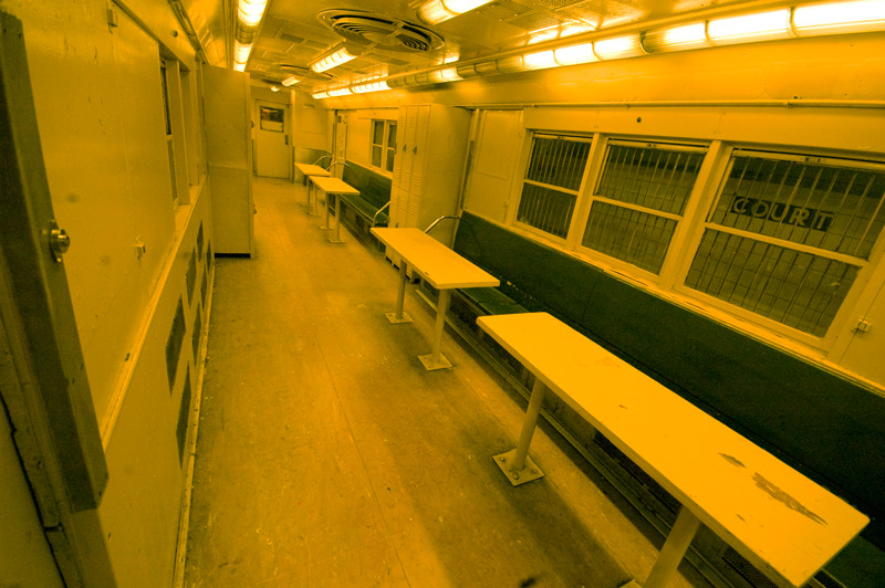 The interior of a subway car, with tables for counting.