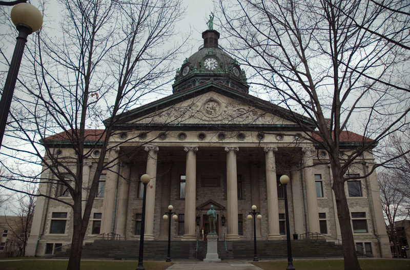 A columned, domed building, with a statue in front.