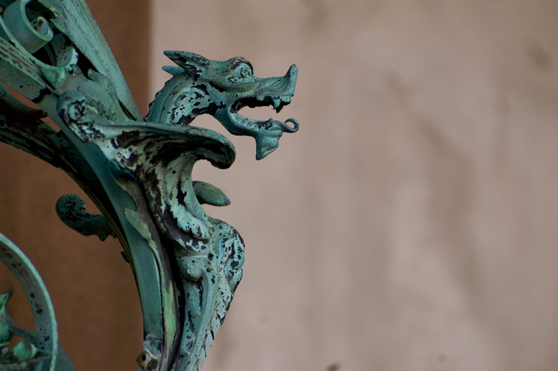 A winged, metal dragon, seen in profile.