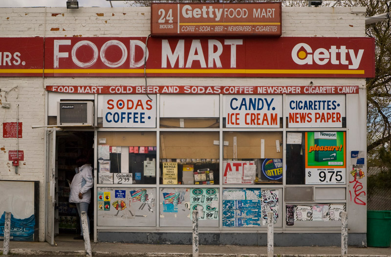 A customer stands in the doorway of a convenience store.