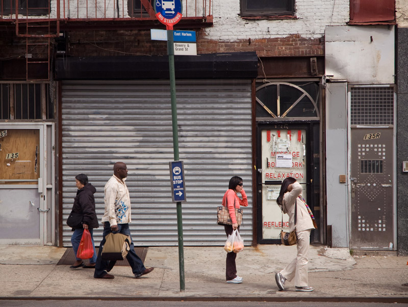 People in a various poses, at a bus stop.