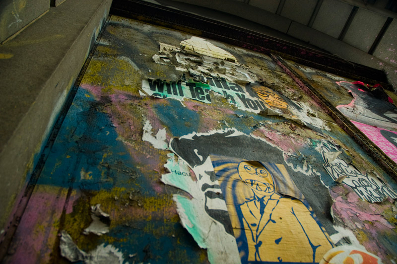 Peeling wheat paste graffiti on a building.