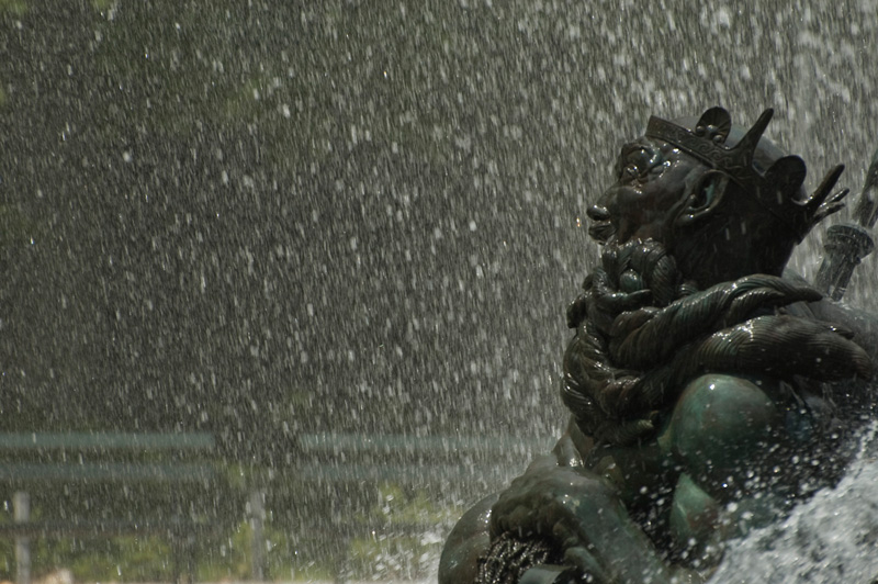 Spray from a water fountain surrounds the upper body of Neptune.