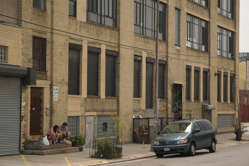 A couple on a stoop, one talking to the other, whose head is down.