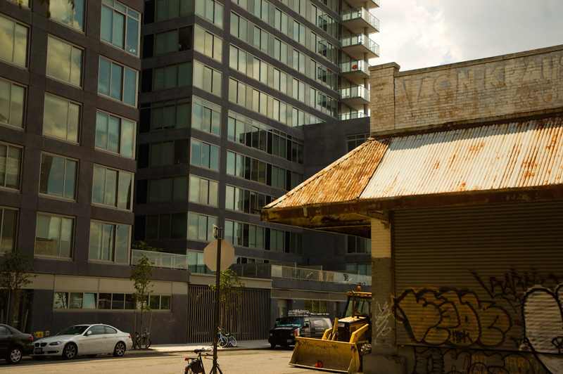 An old storage building, across the street from a glass high rise.