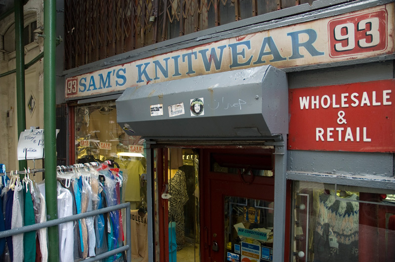 A garment store, with racks of clothing out front.