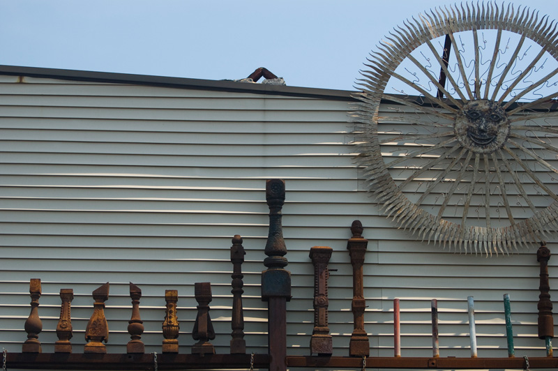 Iron fence posts and a smiling metal sun show an iron monger's skill.