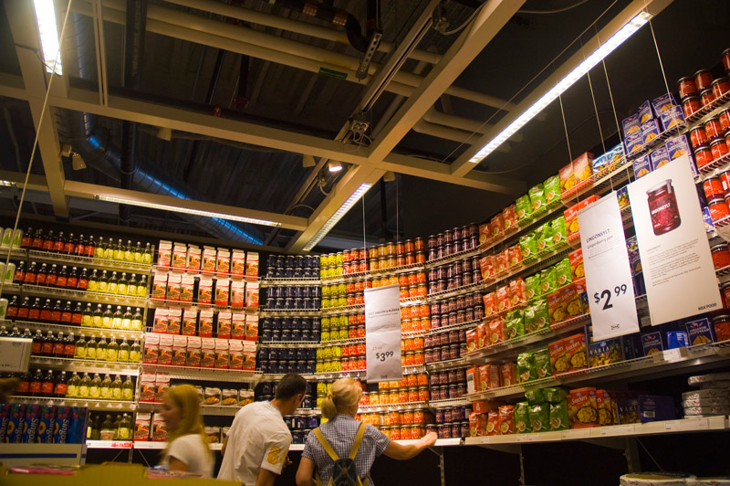 A couple confronts a wall of brightly colored food packages.
