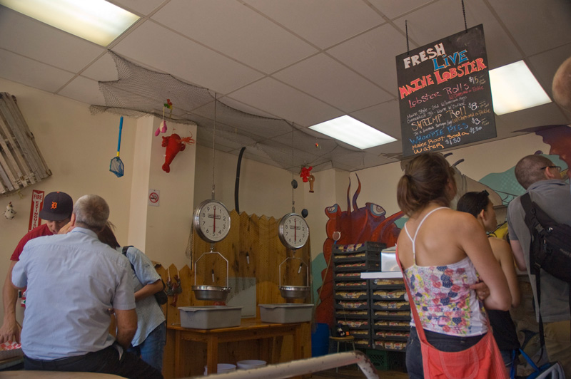 People in line to buy lobster rolls at a take-out counter.