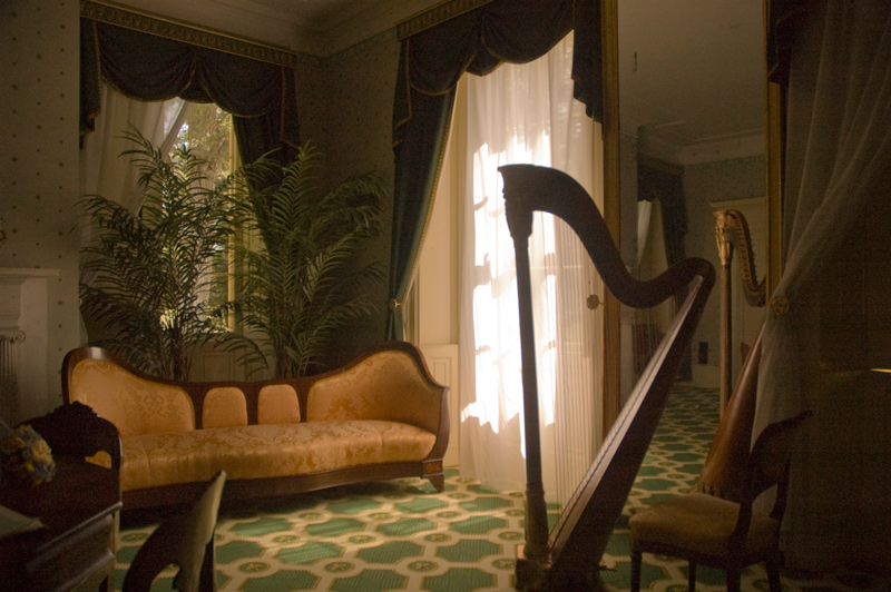 A harp, set in a 19th Century living room.