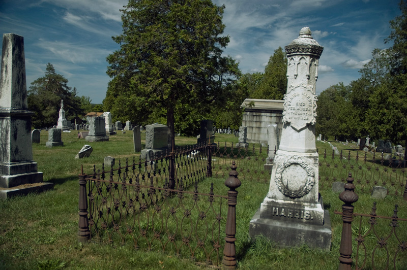 A fenced-off column in a cemetery.