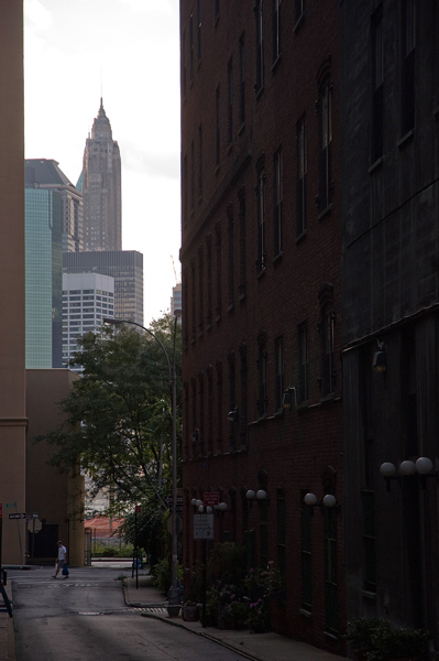 Skyscrapers tower beyond the end of street in shadows.