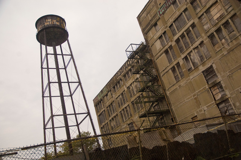 A tall water tower, with 'Save the Palestine' painted on its side.