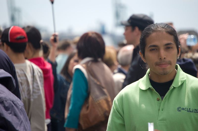 A calm Circle Line employee, surrounded by tourists.