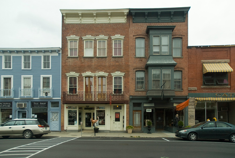Two three-story brick buildings with wood trim.