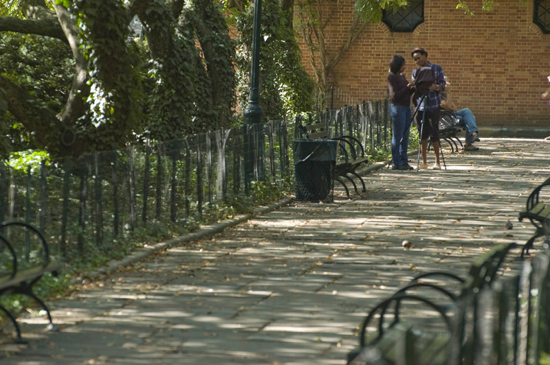 Two people on a Central Park walkway prepare for photography.